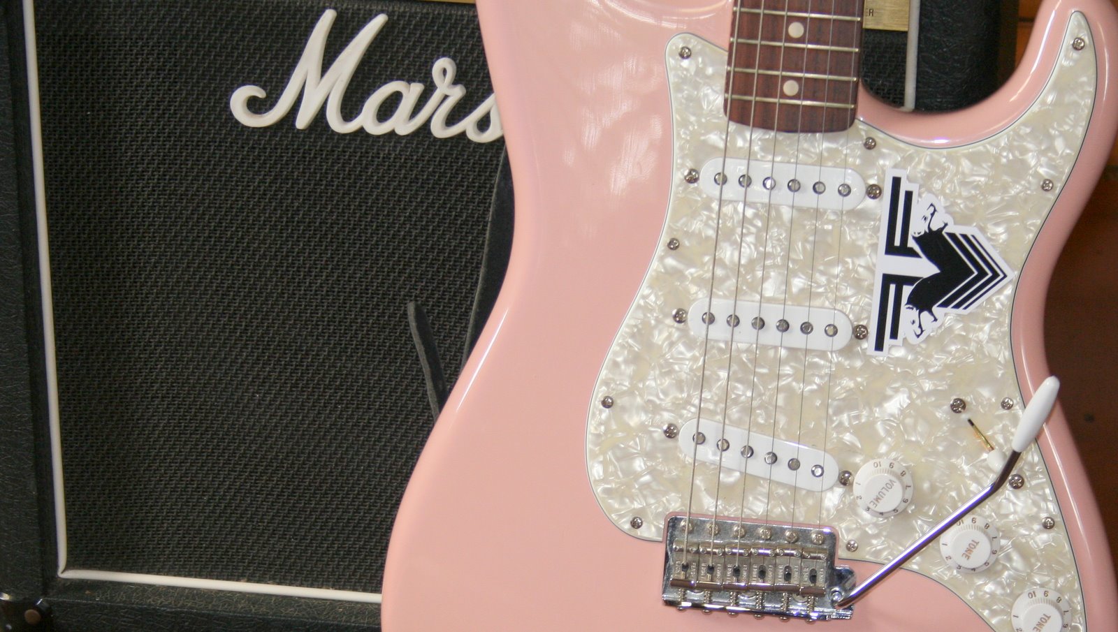 A pink Stratocaster with a whammy bar